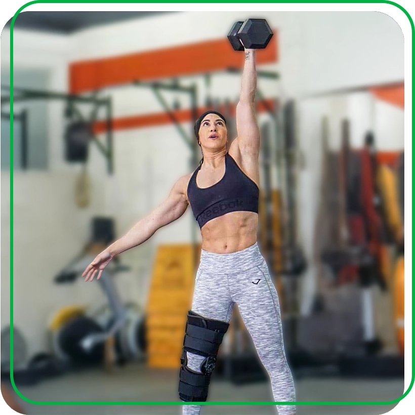 Gina Marie Policastro lifts dumbbell overhead while wearing knee brace